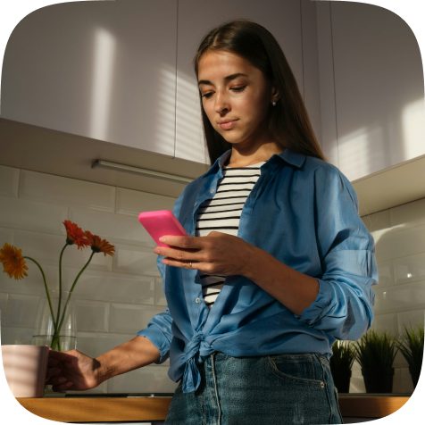 Naine köögis vaatab telefoni