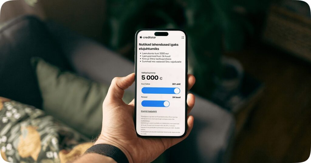 Käsi hoiab telefoni Creditstari äpiga